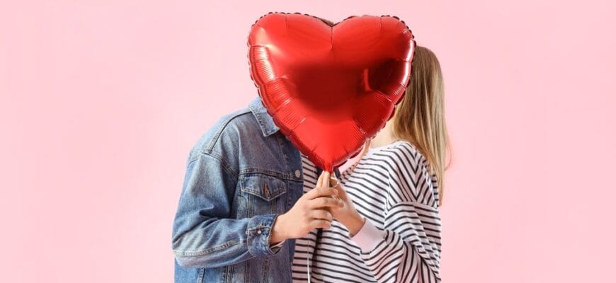 Happy,Young,Couple,With,Beautiful,Heart-shaped,Balloon,On,Pink,Background.
